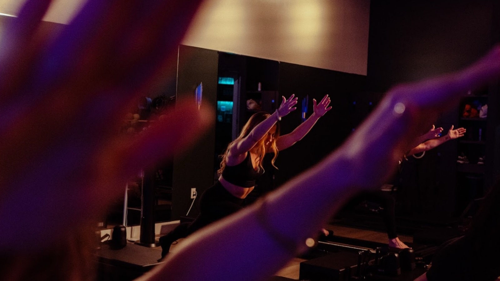 A fast-paced reformer class mid-movement at Oak Cliff Pilates